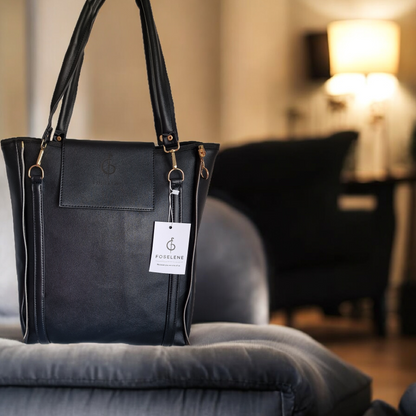 Black handbag with a visible brand tag on a gray surface