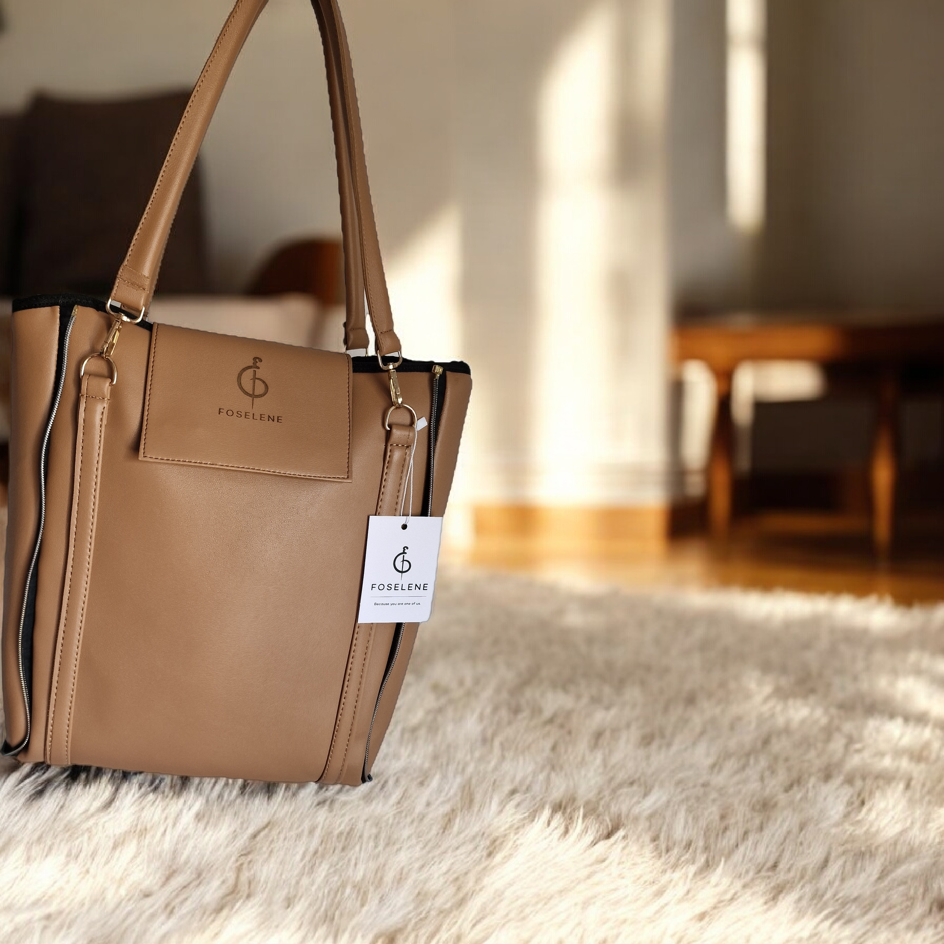 Brown handbag with a visible brand tag on a textured surface