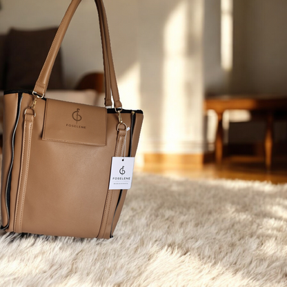 Brown handbag with a visible brand tag on a textured surface